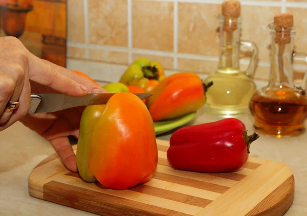 Mulher corta legumes na tábua de corte — Fotografia de Stock