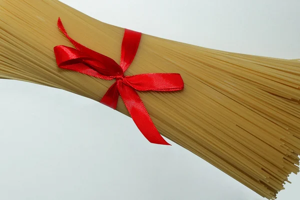 Macarrão, amarrado com fita de cetim vermelho — Fotografia de Stock