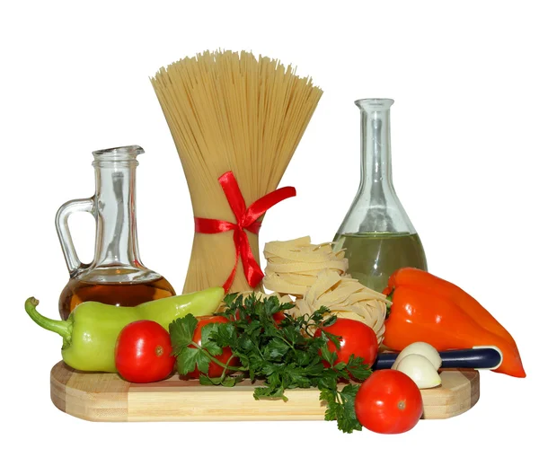 Pasta, pomodori, pepe, verdure e olio d'oliva su un tagliere — Foto Stock