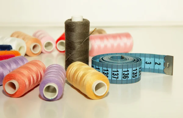 カラフルな糸のスプールのコイル、測定テープに注入する針 — ストック写真