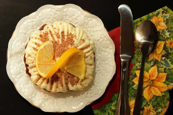 Pastel de chocolate con crema batida y una rebanada de limón en una hermosa servilleta, vista superior — Foto de Stock