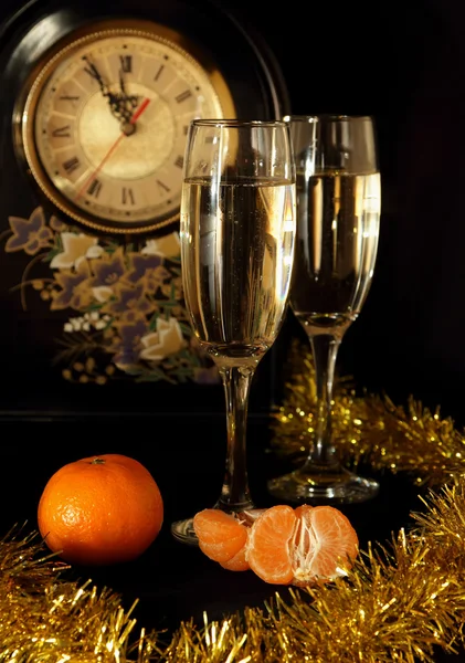 Glazen van champagne, mandarijnen en horloges — Stockfoto