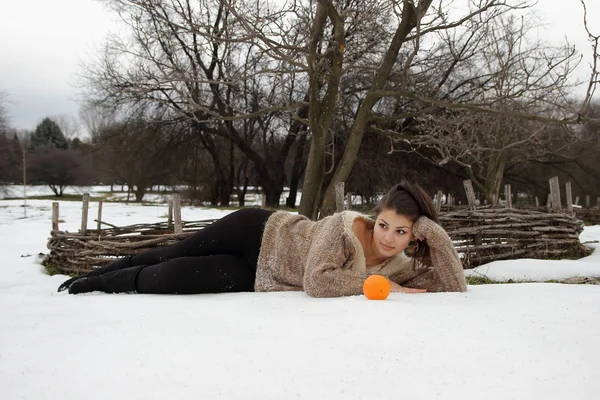 Beautiful girl lying in the snow — Stock Photo, Image