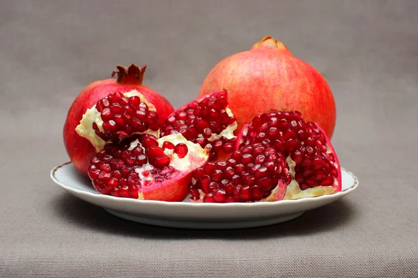 Ripe pomegranate on a plate — Stock Photo, Image