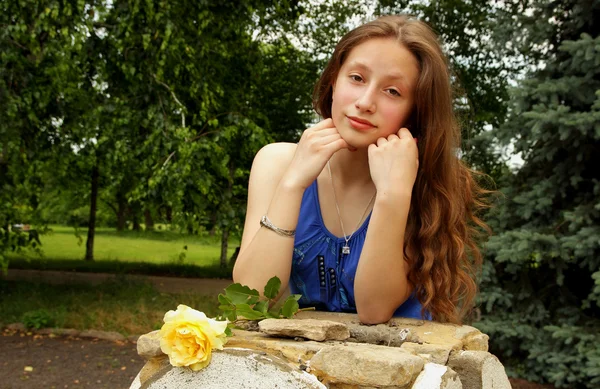 Mooi meisje houdt van een gele roos — Stockfoto