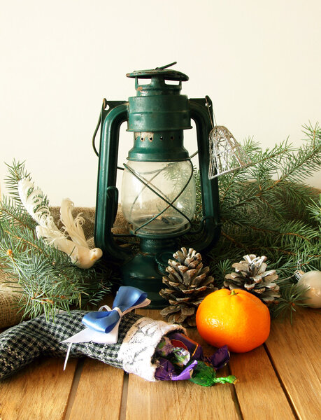 Керосиновый фонарь, конусы, ель и мандарин
