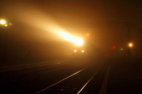 Das Scheinwerferlicht des Personenzuges aus der nebligen Nacht herausgezogen — Stockfoto