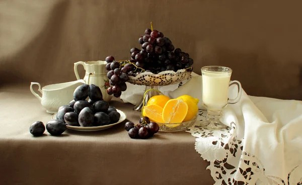 熟透了的葡萄在花瓶里，花和柠檬 — 图库照片