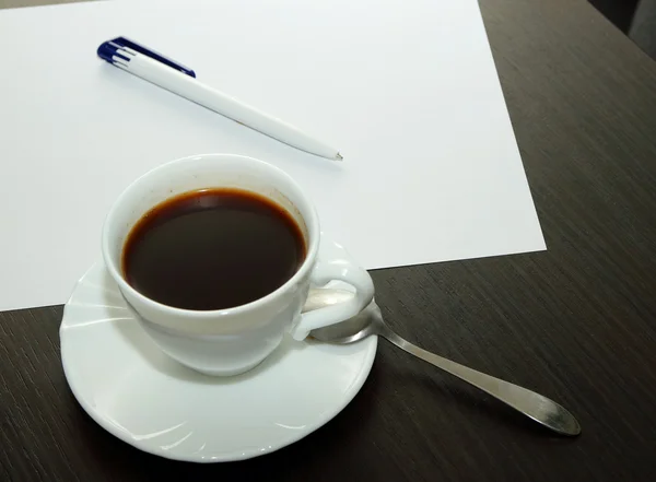 Cup of coffee, a white sheet and pen — Stock Photo, Image