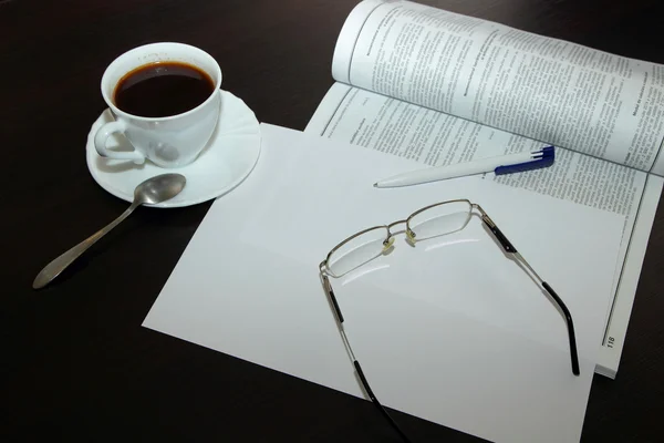 Cup of coffee, a white sheet, glasses and pen — Stock Photo, Image