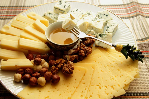 Pedazo de queso en un tenedor, sumergido en miel — Foto de Stock