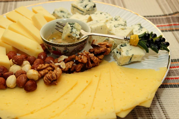 Piece of cheese on a fork, dip in honey — Stock Photo, Image