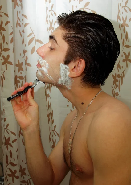 Man with shaving foam on his face before shaving mirror — Stock Photo, Image