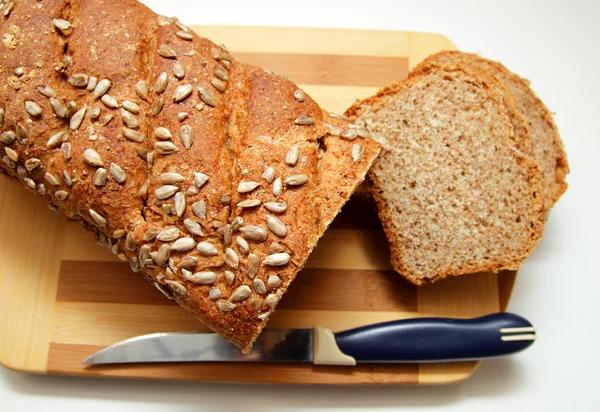Skär i skivor kli bröd, beströs med solrosfrön, ovanifrån — Stockfoto