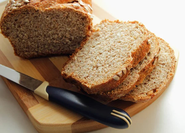 Cut into slices of bran bread, sprinkled with sunflower seeds — Stock Photo, Image