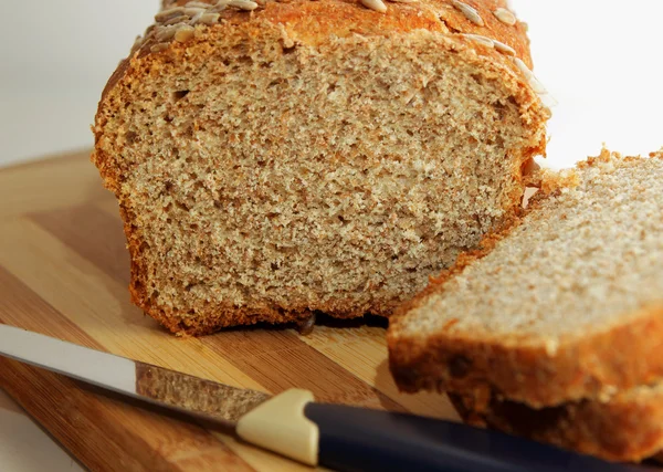 Cut into slices of bran bread, sprinkled with sunflower seeds — Stock Photo, Image