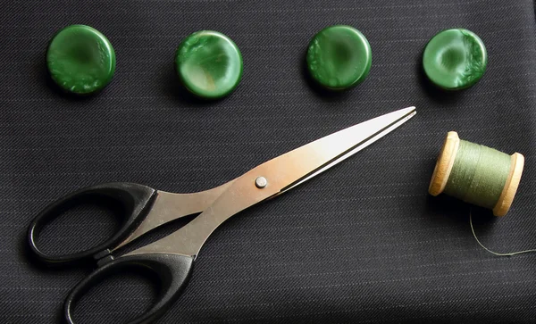 Tela negra, tijeras y botones verdes — Foto de Stock