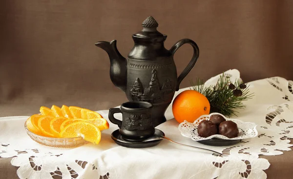 Still life with oranges, sweets and coffee service — Stock Photo, Image