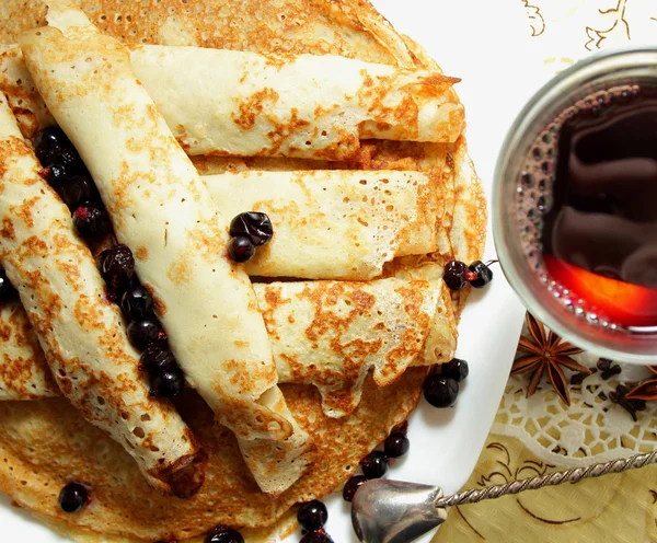 Pancake, digulung ke dalam tabung dan segelas anggur matang panas — Stok Foto