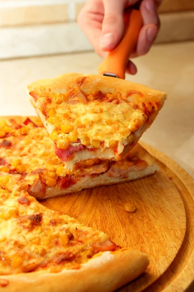 En bit pizza i handen på bladet — Stockfoto