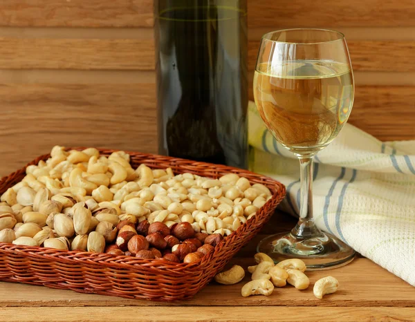 Glas witte wijn, noten en linnen servet — Stockfoto