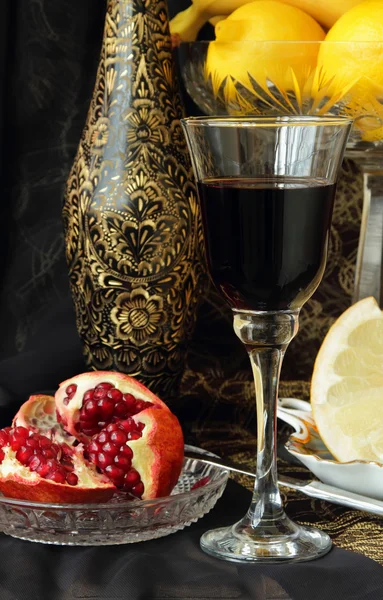Stilleben med ett glas vin och granatäpple — Stockfoto
