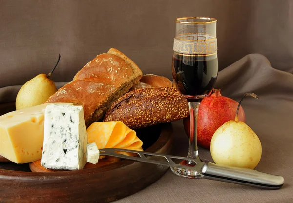 Peynir, bir kadeh şarap ve nar ile natürmort — Stok fotoğraf