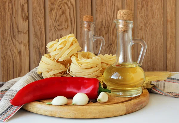 Pasta, peperoni, spezie e bottiglia di olio — Foto Stock
