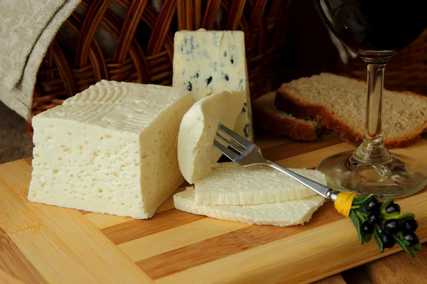 Queso casero, una rebanada de queso en un tenedor y queso —  Fotos de Stock