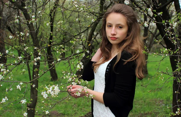 Beautiful girl on a background of flowering trees — Stock Photo, Image