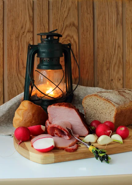 Ham, radishes, bread and a burning lantern — Stock Photo, Image