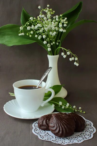 Bukett med liljekonvaljer, en kopp kaffe och marshmallows — Stockfoto