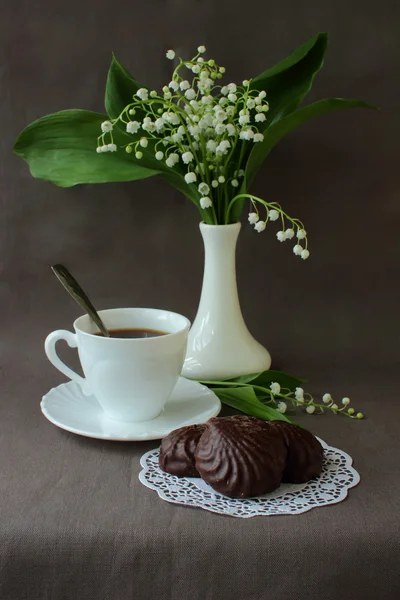 Bukett med liljekonvaljer, en kopp kaffe och marshmallows — Stockfoto