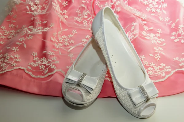 Elegante witte schoenen en een jurk op een meisje — Stockfoto