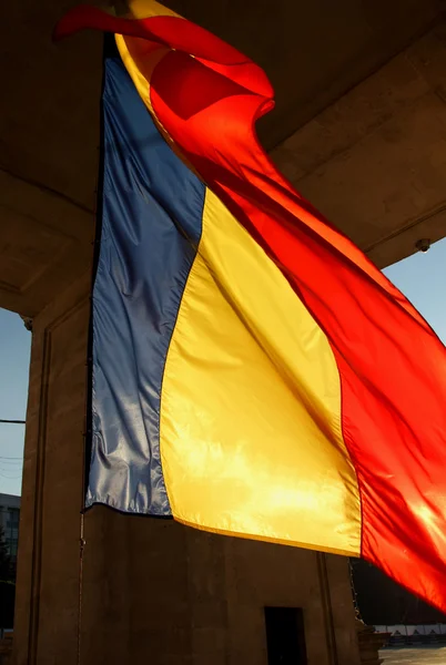 Ondeando bandera tricolor bajo el Arco de la Victoria, iluminado por el sol poniente, Chisinau, Moldavia, 10 de junio de 2014 — Foto de Stock
