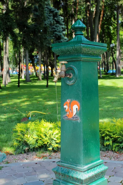 Dotknij lekko otwarte kolumna i płynącej wody na tle parku — Zdjęcie stockowe