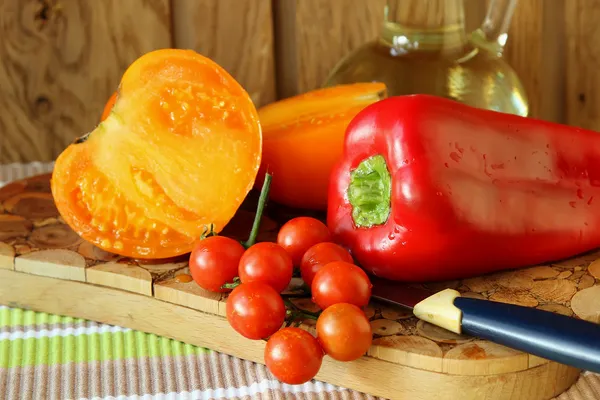 Zralá rajčata a papriky na tabuli — Stock fotografie