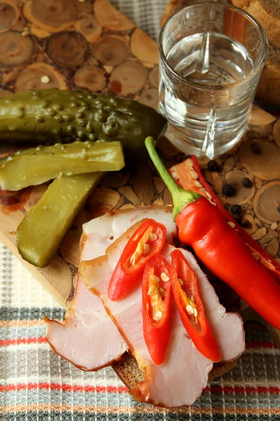 Un vaso de vodka, pan con jamón y chile — Foto de Stock