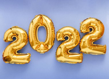 2022 Foil altın balon renkli arka planda izole edilmiş metin şenlikli dekor olarak. Yeni yıl davetiyeniz kutlu olsun 2022 yılbaşı balonlarıyla