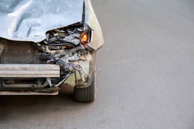 Kopya uzay olmadan araba kazasından sonra araba kaputu kırılmış. Kırık araba çöp yığını. Aydınlık Kırık Çarpıcı ve Araba Farları Yol yüzeyinde asfalt ve kopyalama alanı.