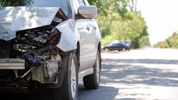 Autóbalesetet szenvedett a városi úton, autóbalesetben. Összetört elülső fényszóró, behorpadt motorháztető lökhárító nélkül autóbalesetben. Autó- és egészségbiztosítás. Hosszú Web banner — Stock Fotó