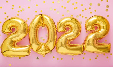 2022 yıllık altın balonlar pembe arka planda konfeti ile mesajlaşıyor. Yeni yılın kutlu olsun 2022 mektup arifesi kutlaması. Mutlu Noeller konsepti. Uzun web pankartı