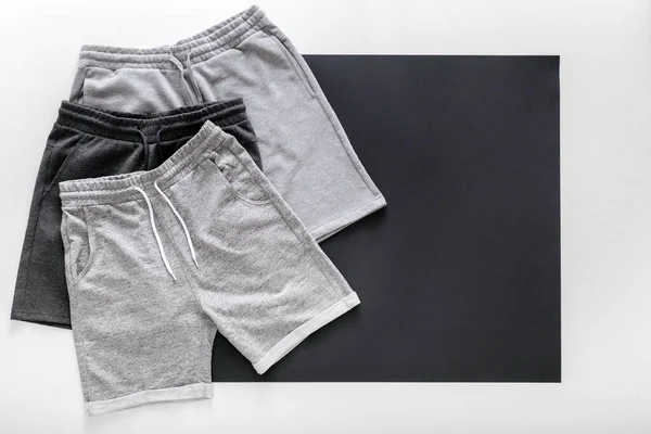 Set gray black shorts pants for man sport. Set Various of Basic casual clothing sports gray male shorts On white black frame background. Minimalistic basic clothing concept. Top View Copy space — Stock Photo, Image