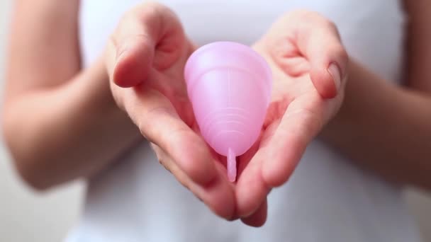 Las manos femeninas muestran el uso de copa menstrual. Mano de mujer sosteniendo copa menstrual. Higiene íntima femenina período cero productos de desecho. Concepto de salud femenina. — Vídeos de Stock