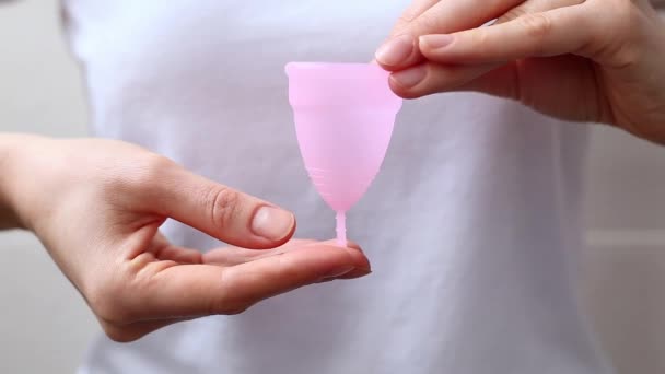 Le mani femminili mostrano utilizzando tazza mestruale. Donna mano che tiene la tazza mestruale. Periodo di igiene intima femminile zero rifiuti prodotti. Concetto di salute femminile. — Video Stock