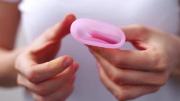 Las manos femeninas muestran el uso de la copa menstrual de cerca. Mano de mujer sosteniendo copa menstrual. Higiene íntima femenina período cero productos de desecho. Concepto de salud femenina. — Vídeos de Stock