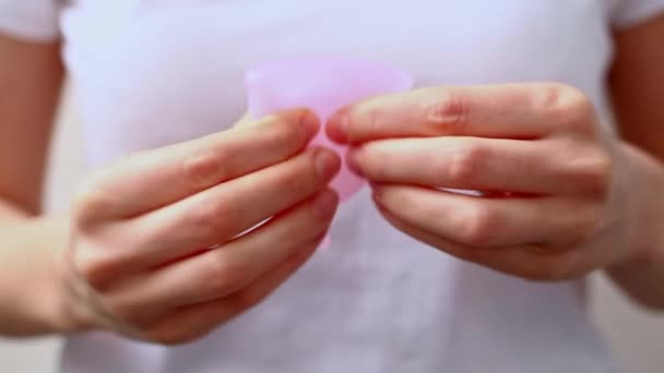 Mužské ruce ukazují pomocí menstruačního kelímku. Ženská ruka držící menstruační pohár. Žena intimní hygiena období nulový odpad produkty. Zdravotní koncepce žen. — Stock video