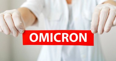 Omicron kırmızı uyarı işareti. Yeni Omicron varyantı Cavid 19 beyaz önlüklü ve eldivenli doktorların elinde. Uzun web pankartı