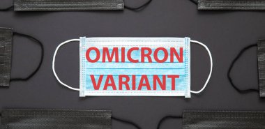 Yeni Omicron varyasyon covid 19 metin yüz maskesi üzerinde siyah arkaplanda izole. Tıbbi koruyucu siyah maske için Omicron 'a mesaj geldi. Uzun web pankartı