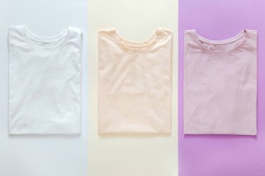  Renkli t-shirtler renklendirici renkler Pembe Beyaz Mor Mockup. Renkli arka plan tasarımı için. Yığınlanmış temel t-shirtler modaya uygun minimalist konsept. Tişörtler düz..